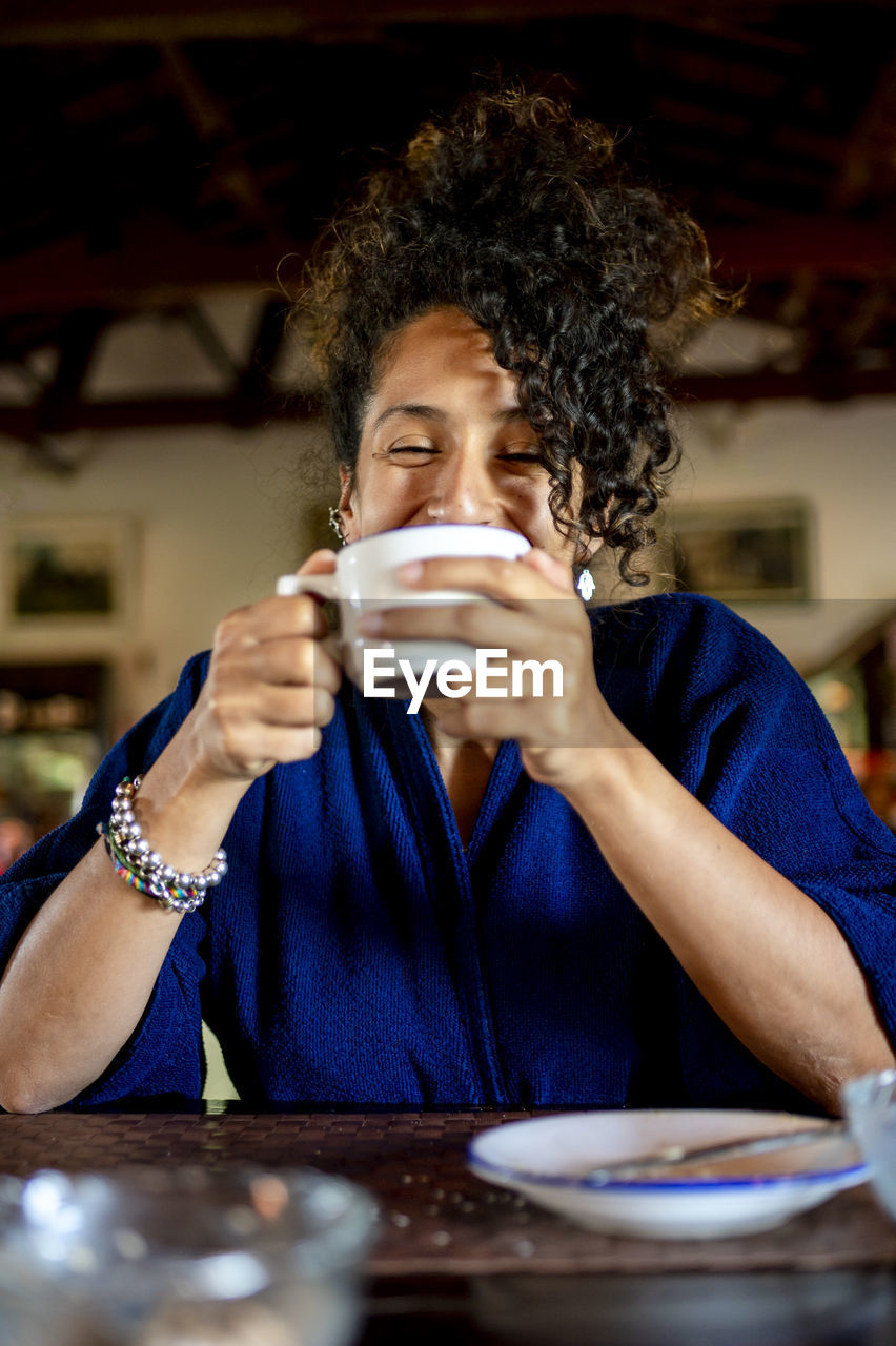 Relaxed woman smiling and drinking a cup of coffee