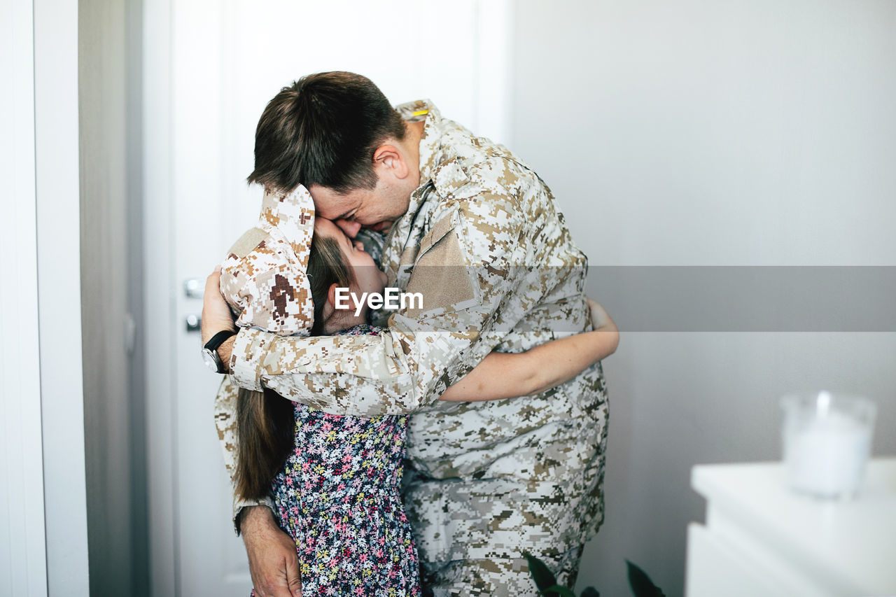 Father kissing daughter at home