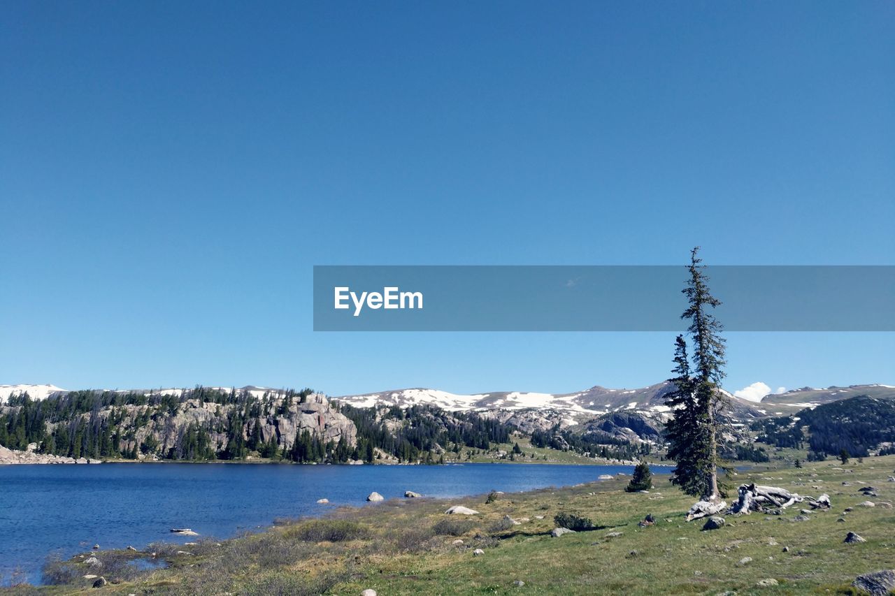 Scenic view of mountains against clear blue sky