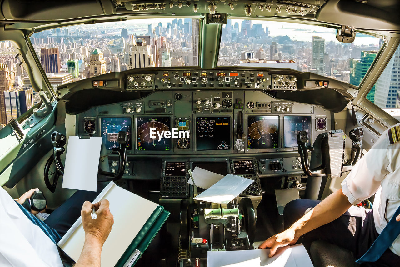 Pilots sitting in cockpit over city