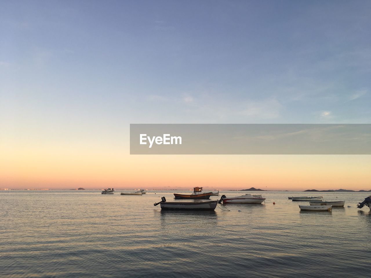 VIEW OF BOATS IN SEA AT SUNSET