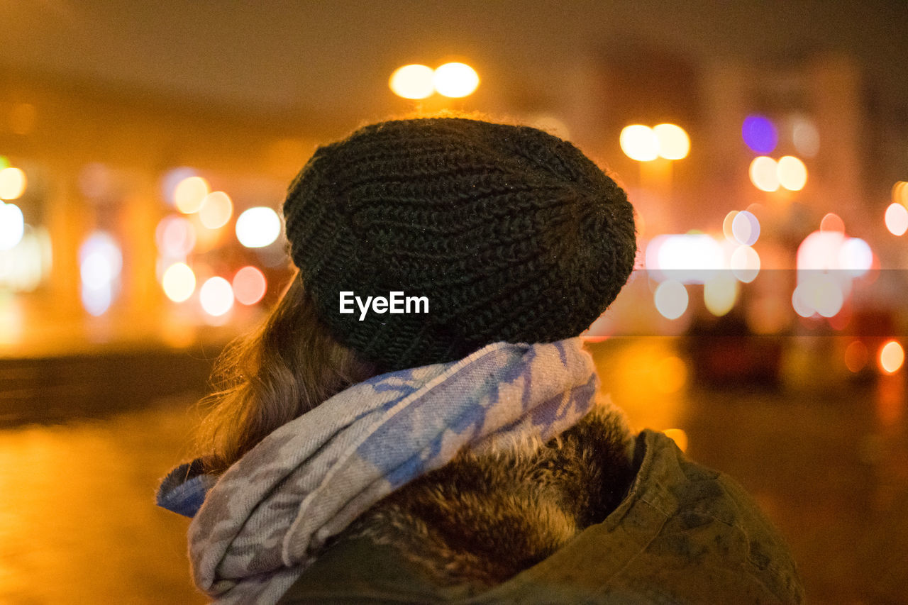Rear view of woman in illuminated park during winter