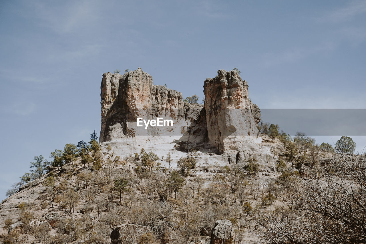 LOW ANGLE VIEW OF ROCK FORMATIONS ON LAND AGAINST SKY