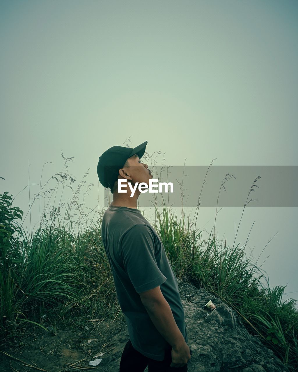 MAN STANDING ON FIELD AGAINST SKY