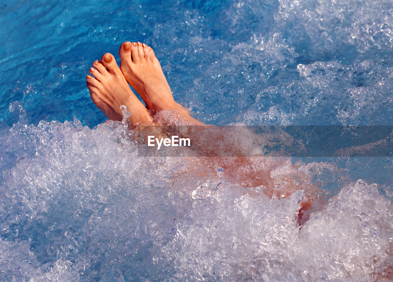 Low section of woman swimming in sea