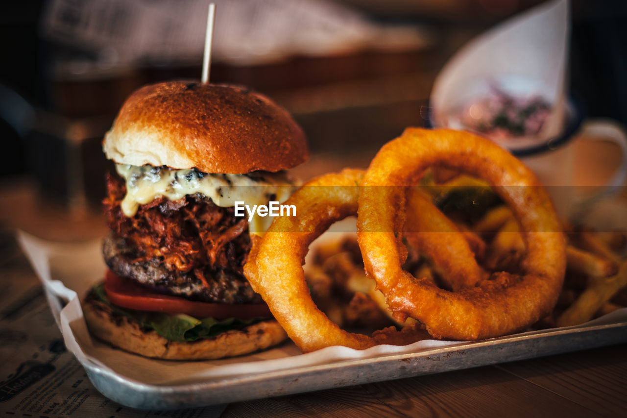 Close-up of burger and onion rings on table