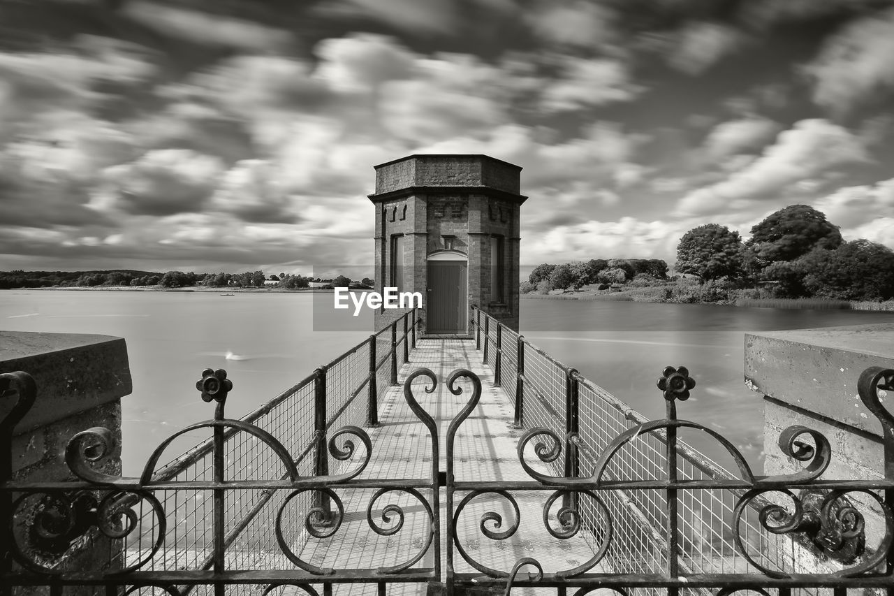 Building by lake against sky