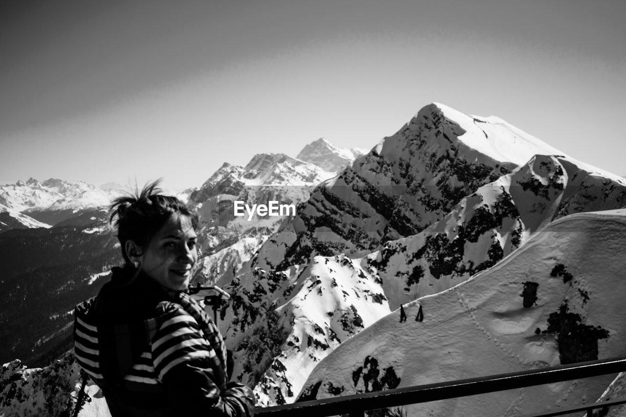 Man standing on snowcapped mountain against sky