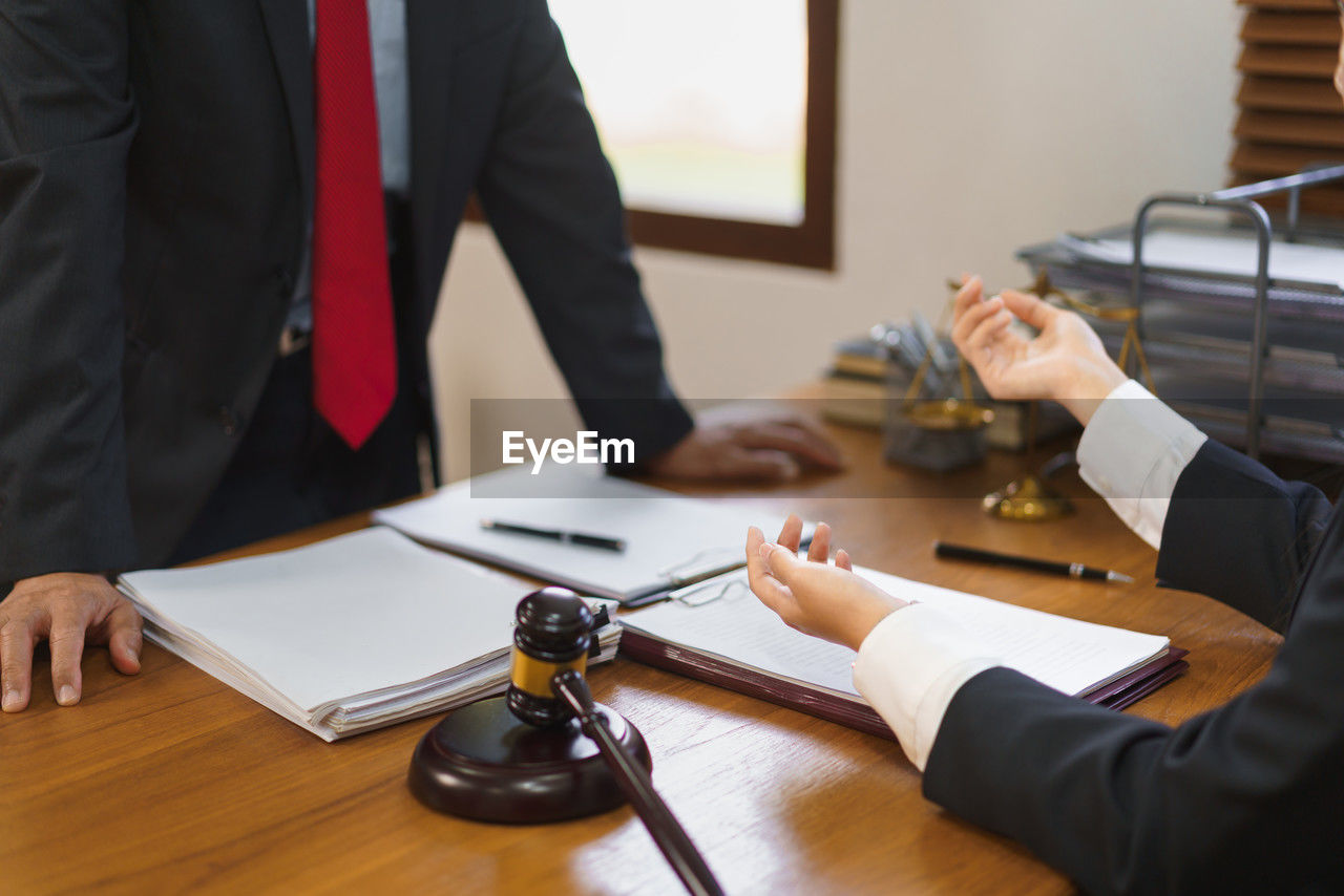 midsection of lawyer working at desk in office