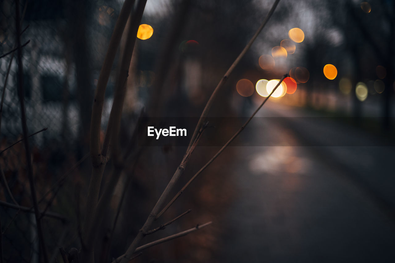 Close-up of illuminated lighting equipment on road at night
