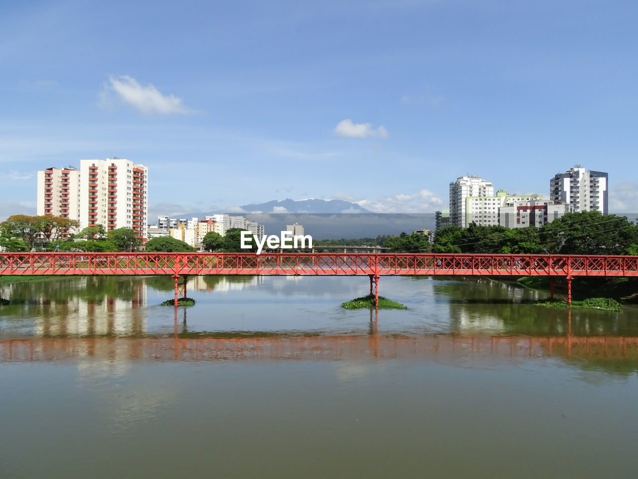 Buildings by river against sky in city