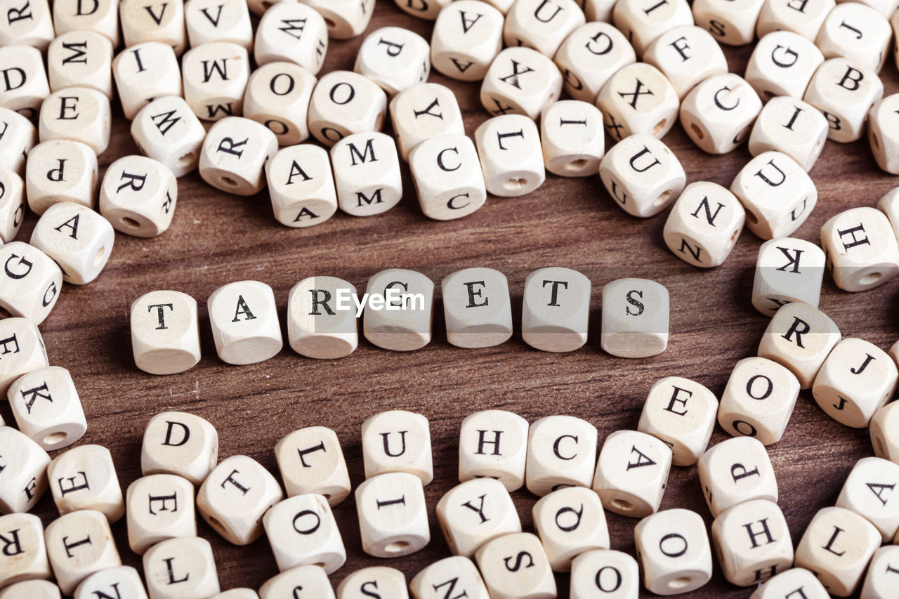 Word targets in letters on cube dices on table.