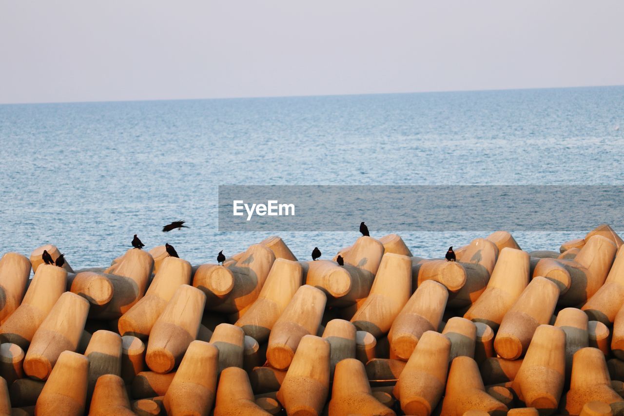 STACK OF STONES ON SEA AGAINST CLEAR SKY