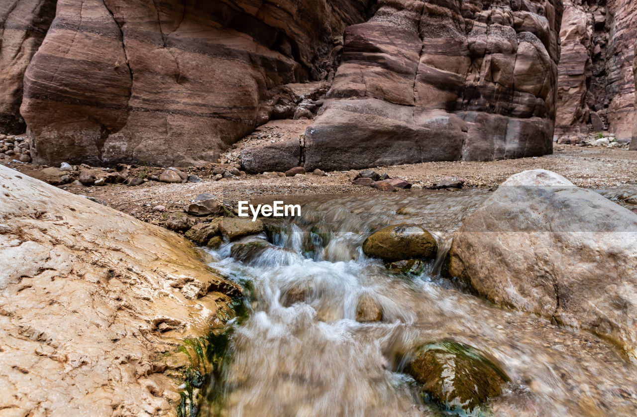 rock, wadi, beauty in nature, nature, scenics - nature, rock formation, water, wilderness, land, valley, non-urban scene, no people, canyon, environment, geology, waterfall, river, day, motion, tranquility, landscape, outdoors, flowing water, travel destinations, plant, travel, flowing, tranquil scene, physical geography, tree