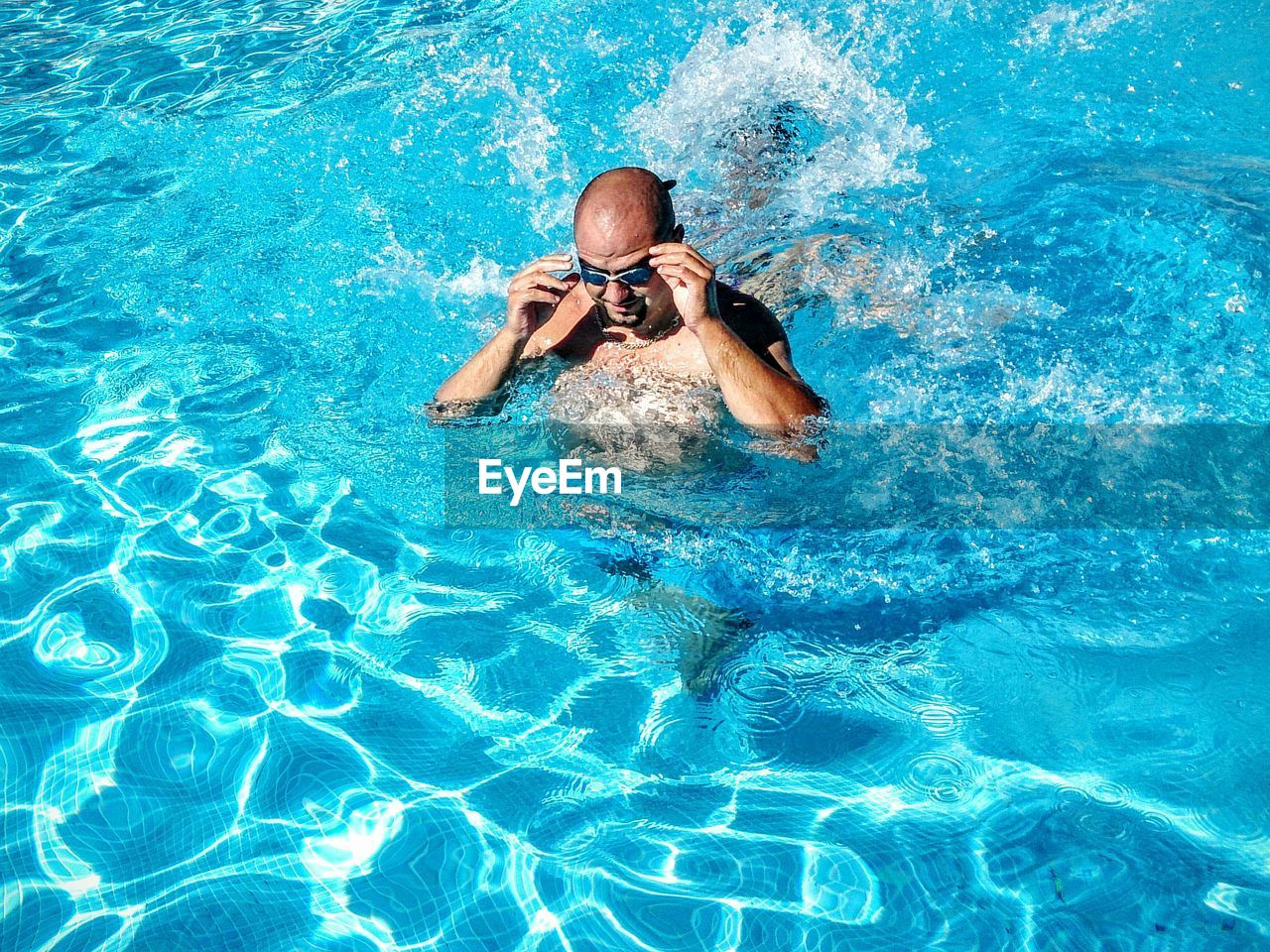 High angle view of man wearing goggles in swimming pool
