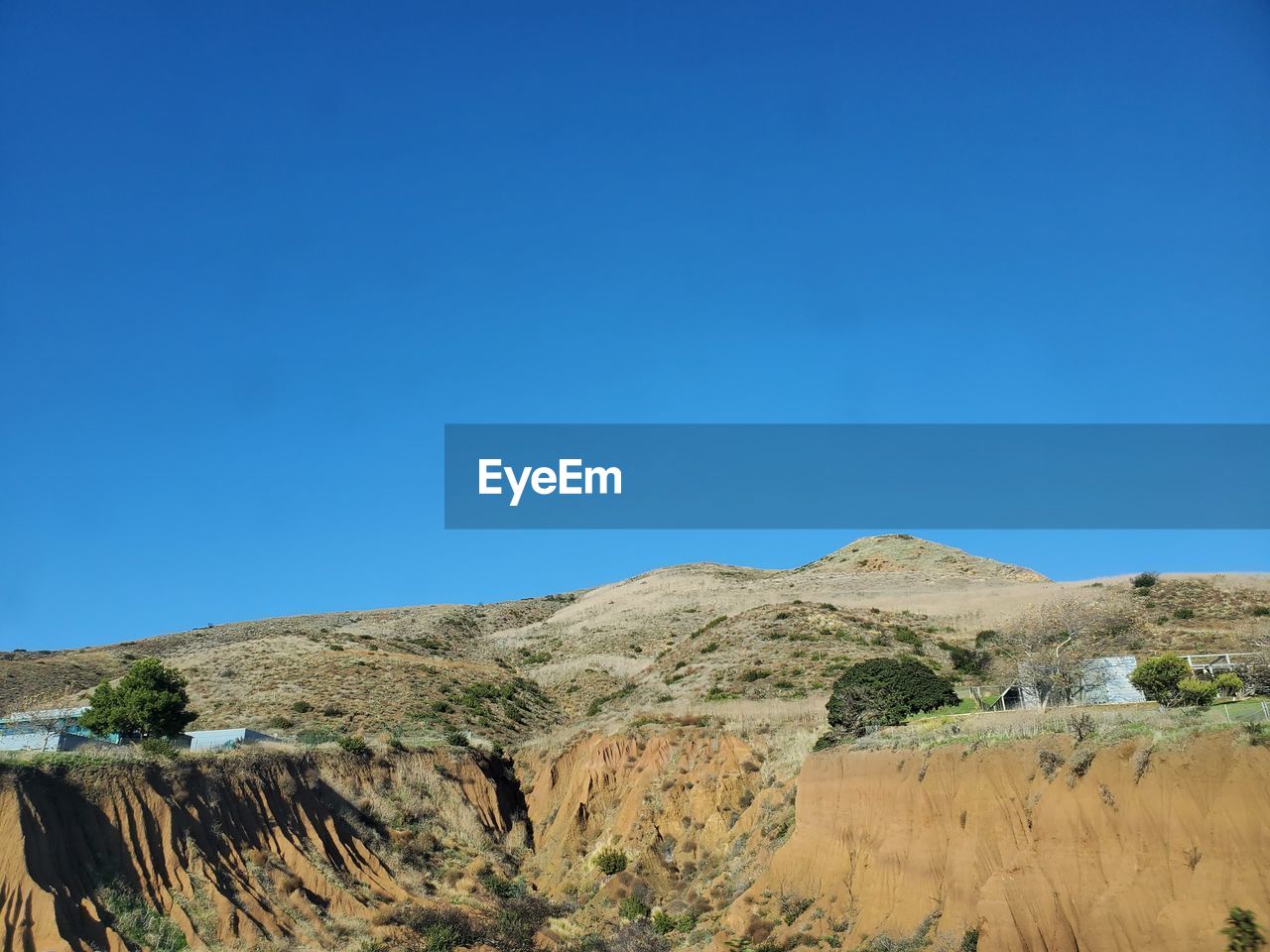 Scenic view of desert against clear blue sky