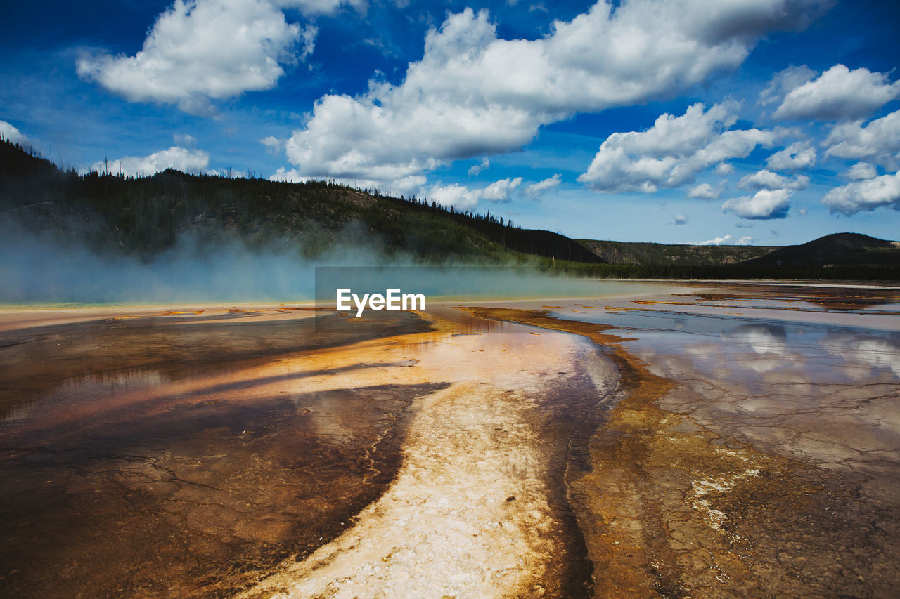 Scenic view of hot springs at yellowstone national park against cloudy sky