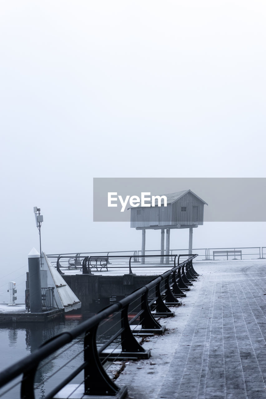 Stilt house on pier during foggy weather in winter