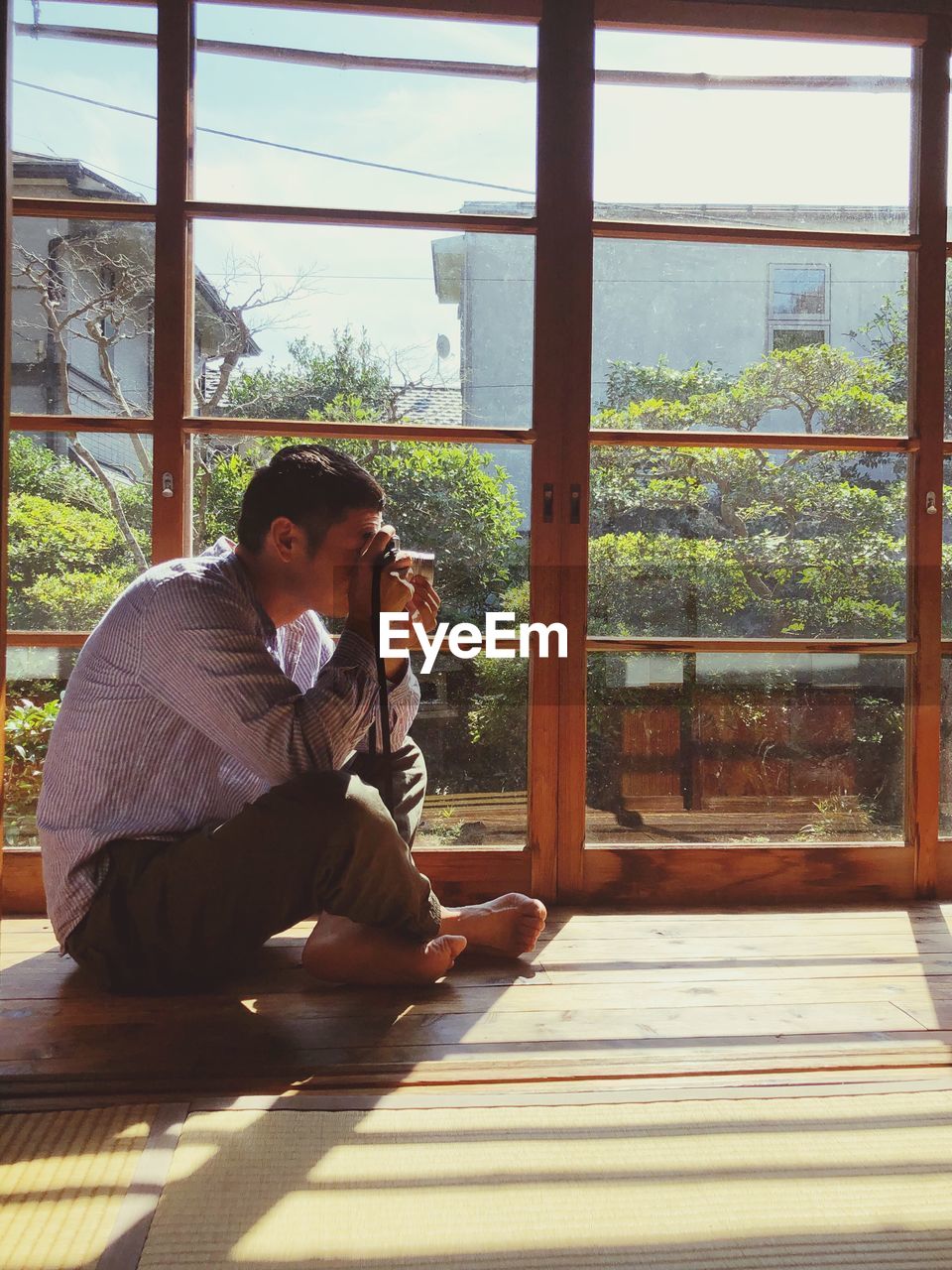 MAN SITTING BY WINDOW