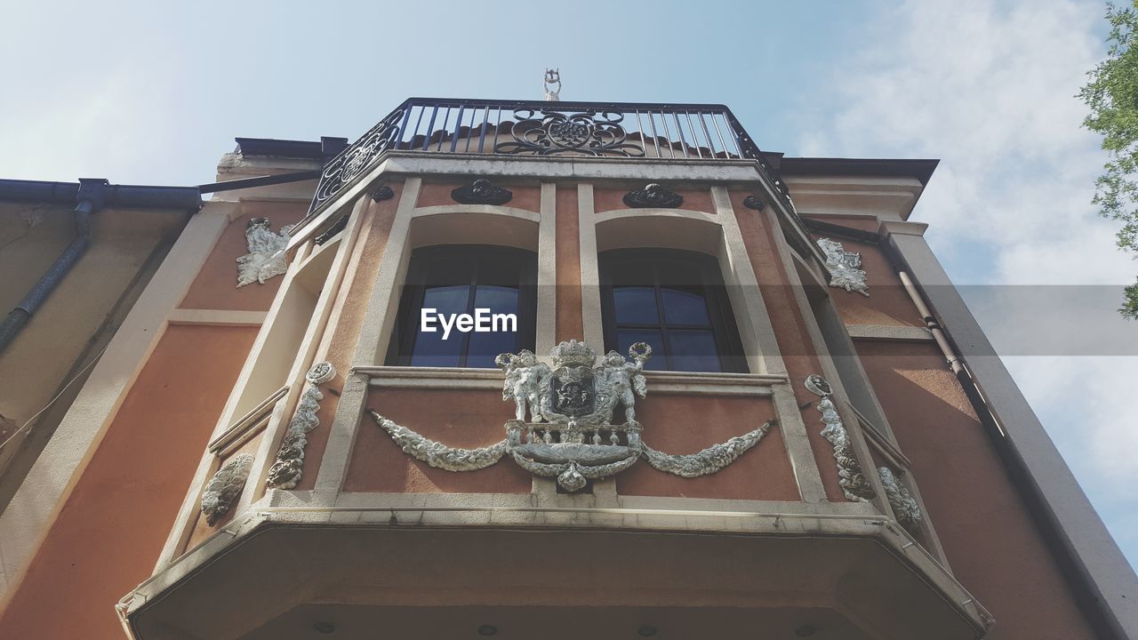 LOW ANGLE VIEW OF SCULPTURE ON BUILDING AGAINST SKY