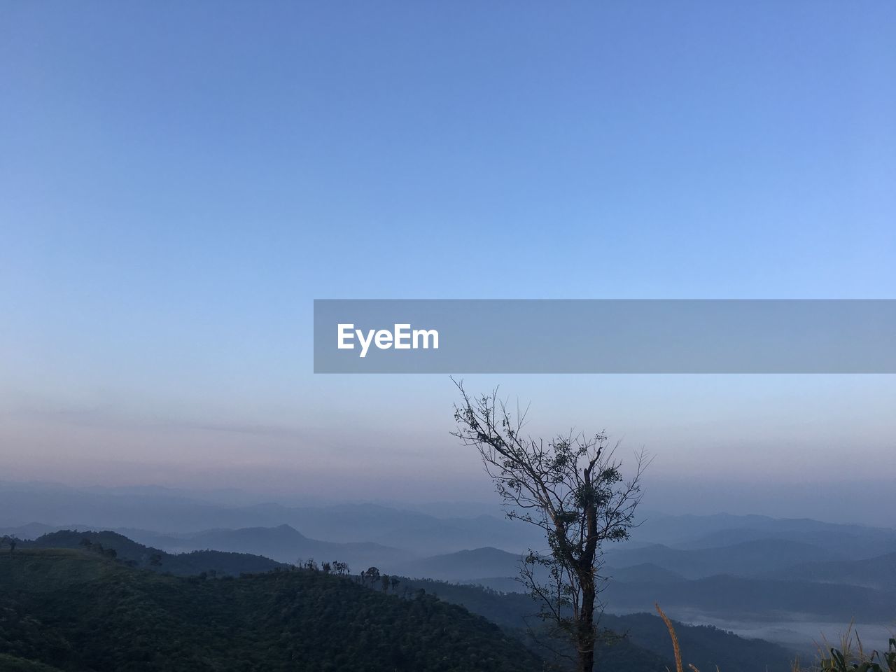 Scenic view of mountains against clear sky at sunset