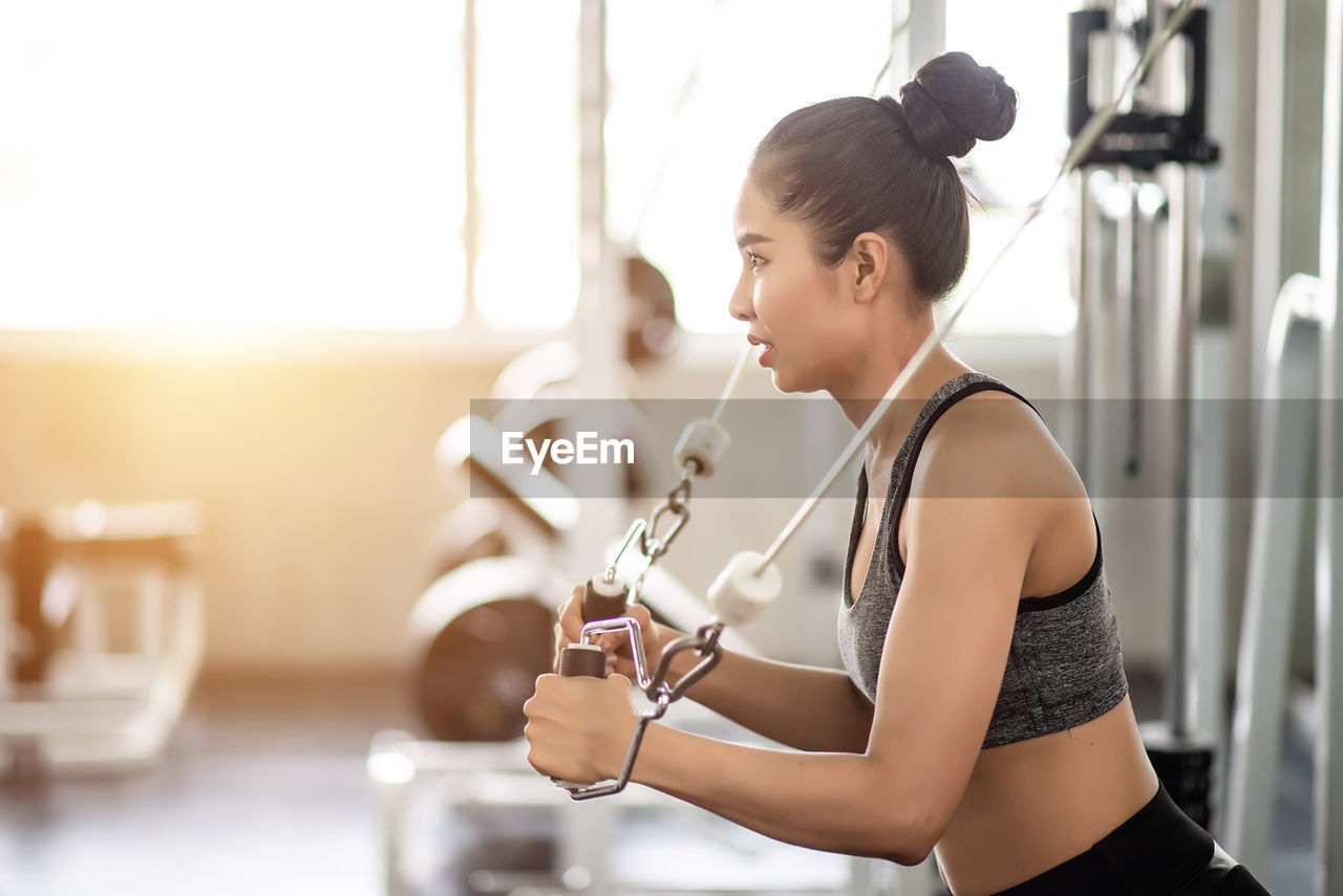 Side view of woman exercising in gym