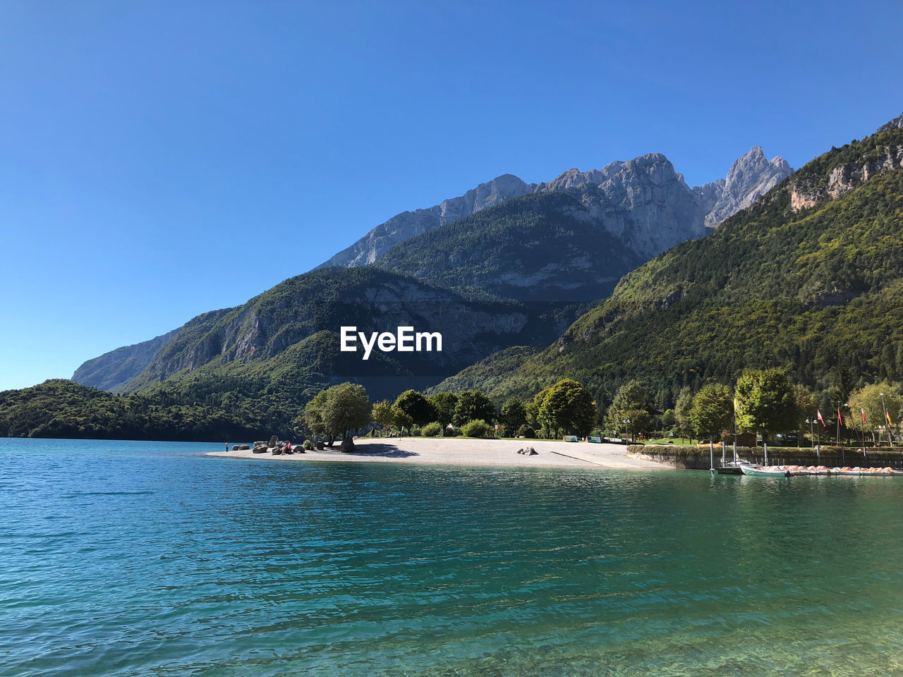 Scenic view of sea and mountains against clear blue sky