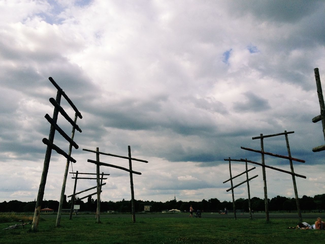 View of poles on countryside landscape against clouds