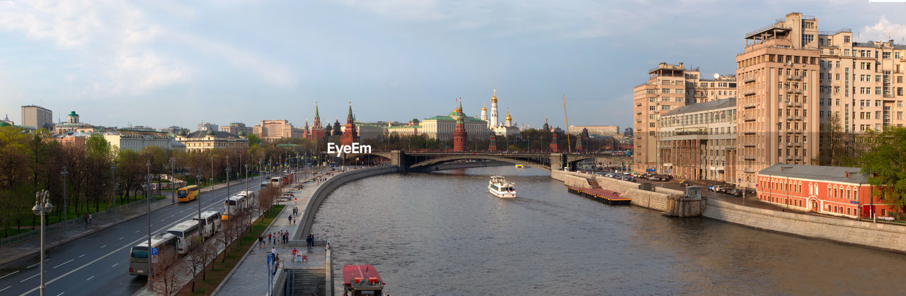 Panoramic view of river amidst buildings in city against sky