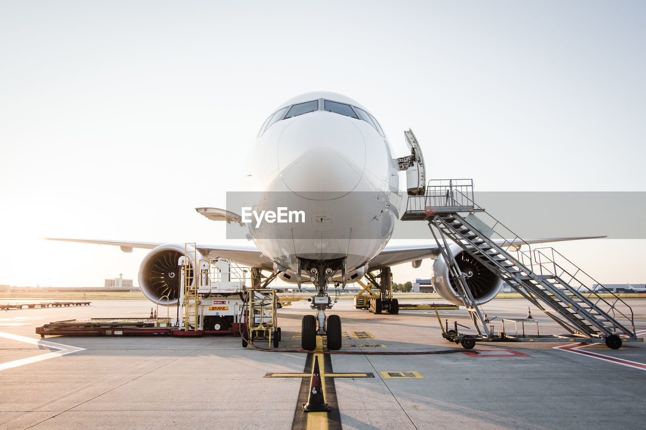 Airplane at runway against sky