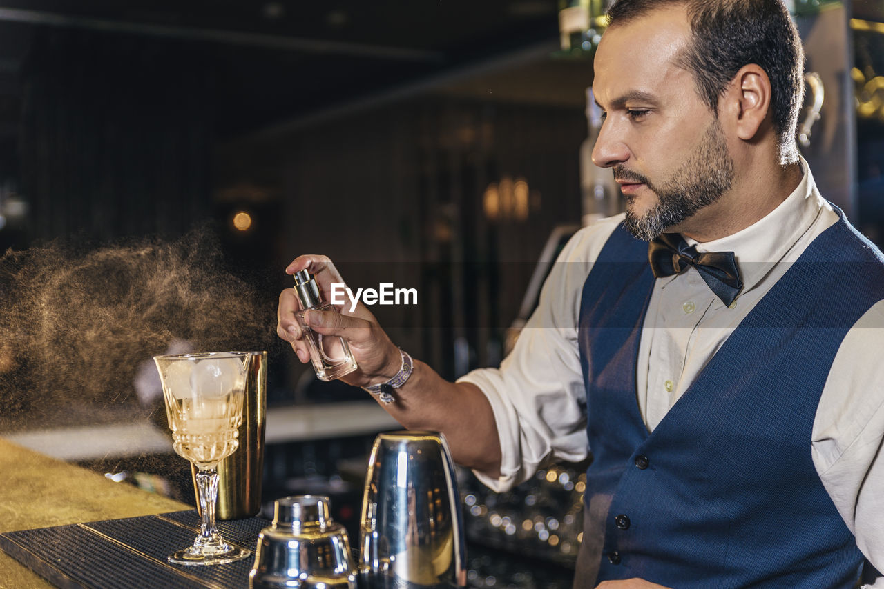 Bartender making drinks on counter in bar