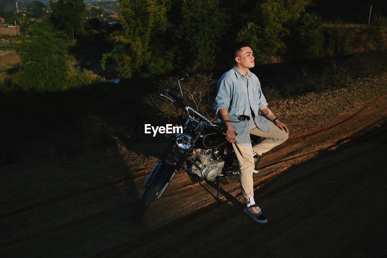 FULL LENGTH PORTRAIT OF MAN ON MOTORCYCLE