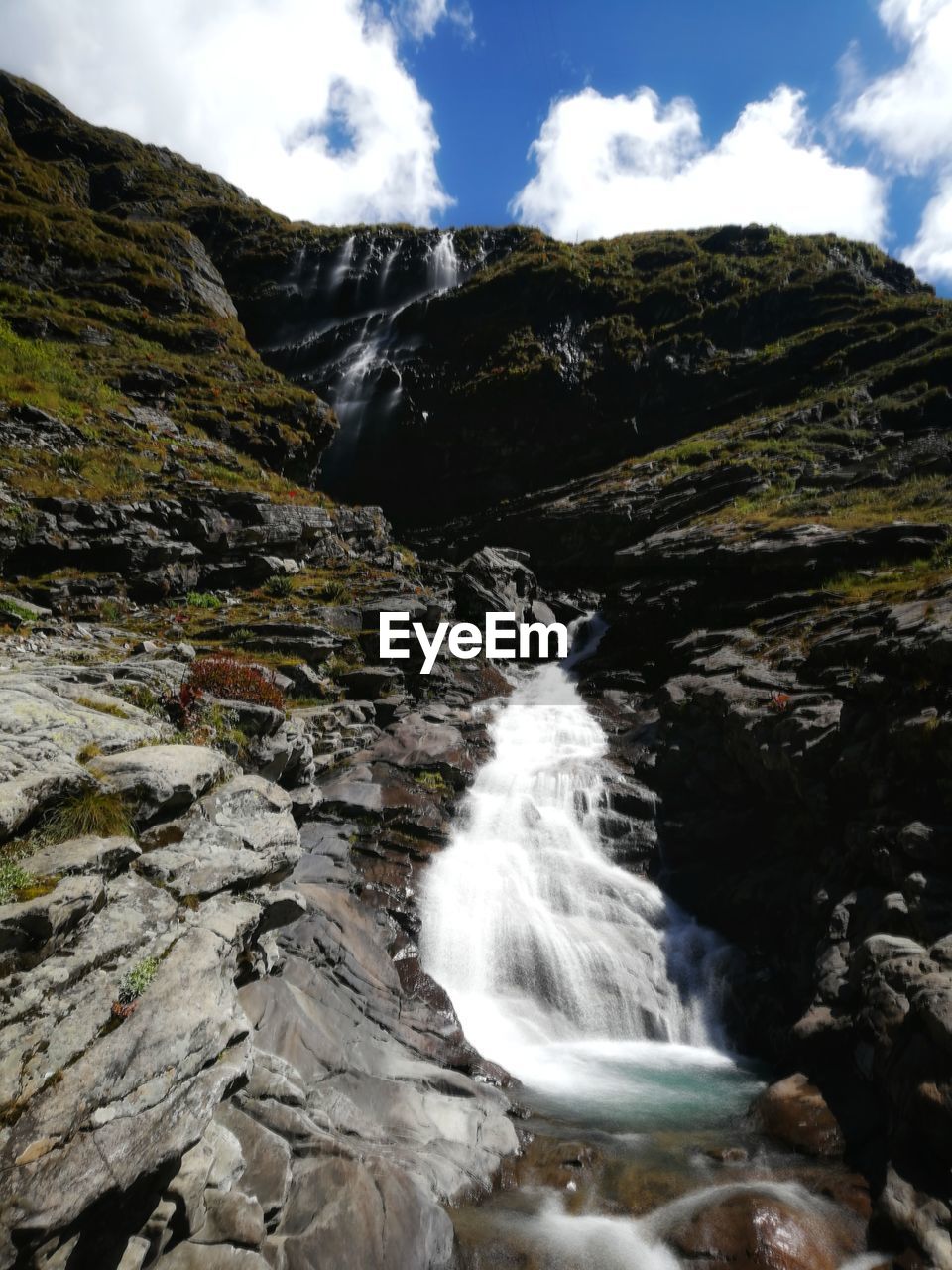 Scenic view of waterfall against sky