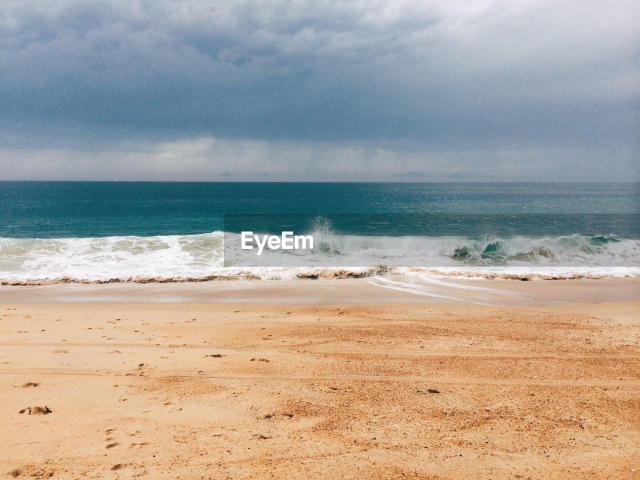 Scenic view of sea shore against cloudy sky