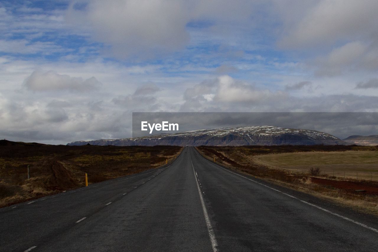 EMPTY ROAD ALONG LANDSCAPE AND MOUNTAINS