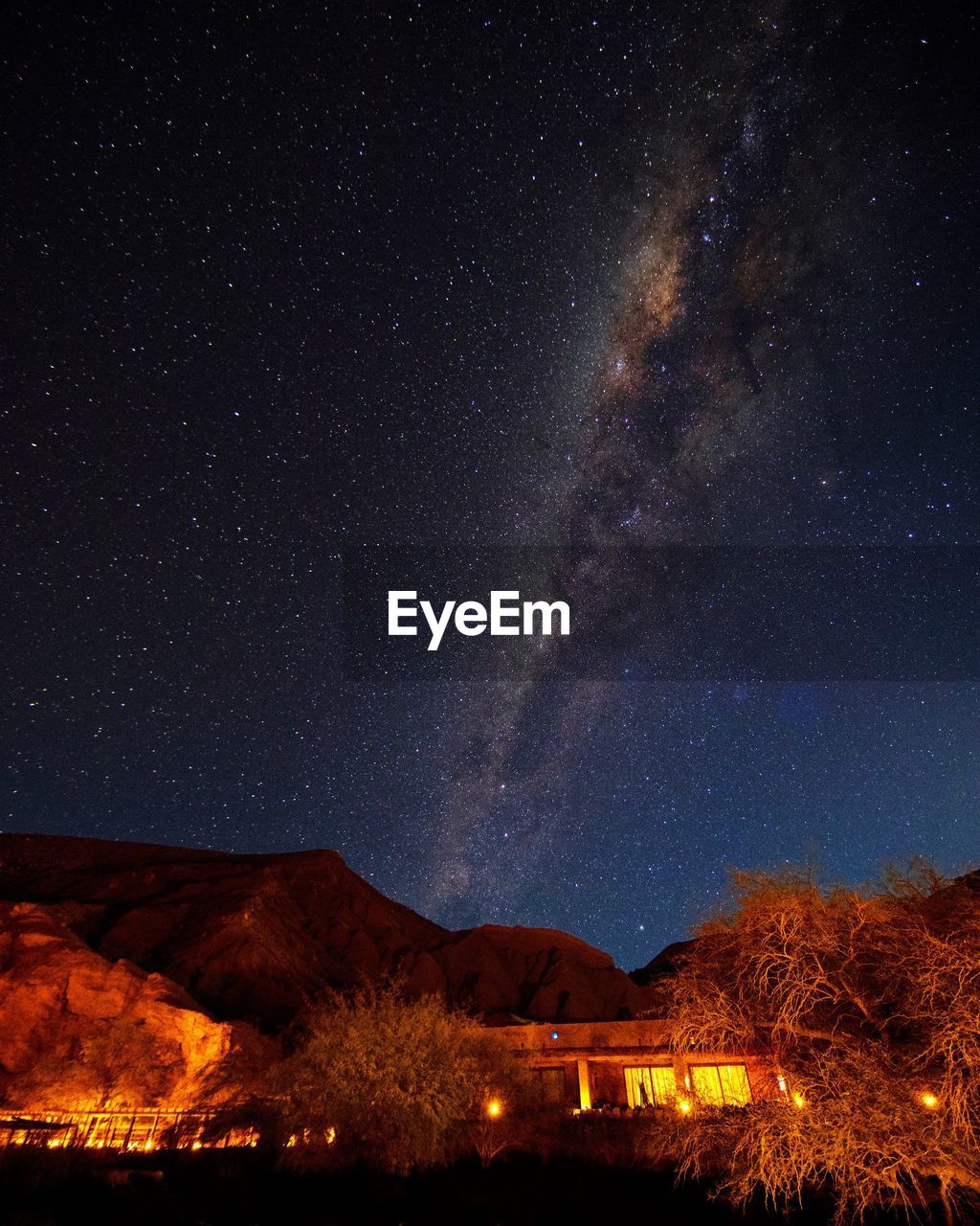 Scenic view of illuminated mountain against milky way sky 