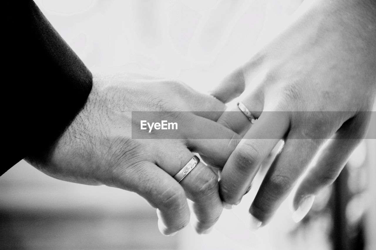 Cropped image of couple hands with wedding rings