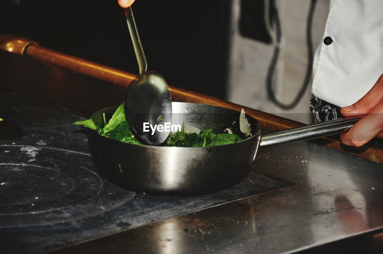 Midsection of person preparing food in kitchen