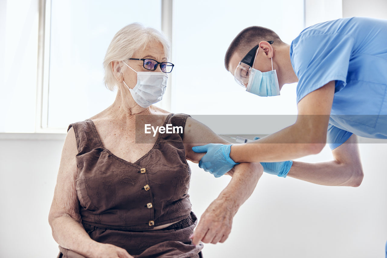 Side view of doctor examining patient at clinic