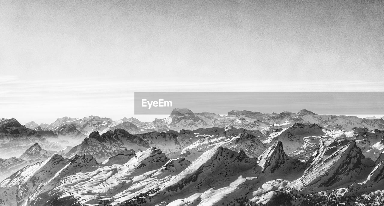 black and white, environment, landscape, mountain, scenics - nature, monochrome photography, monochrome, mountain range, beauty in nature, sky, nature, no people, tranquility, snow, land, tranquil scene, travel destinations, cloud, cold temperature, travel, rock, extreme terrain, non-urban scene, winter, outdoors, day, panoramic, mountain peak, dramatic landscape, physical geography, idyllic, rock formation, tourism, remote, copy space, snowcapped mountain