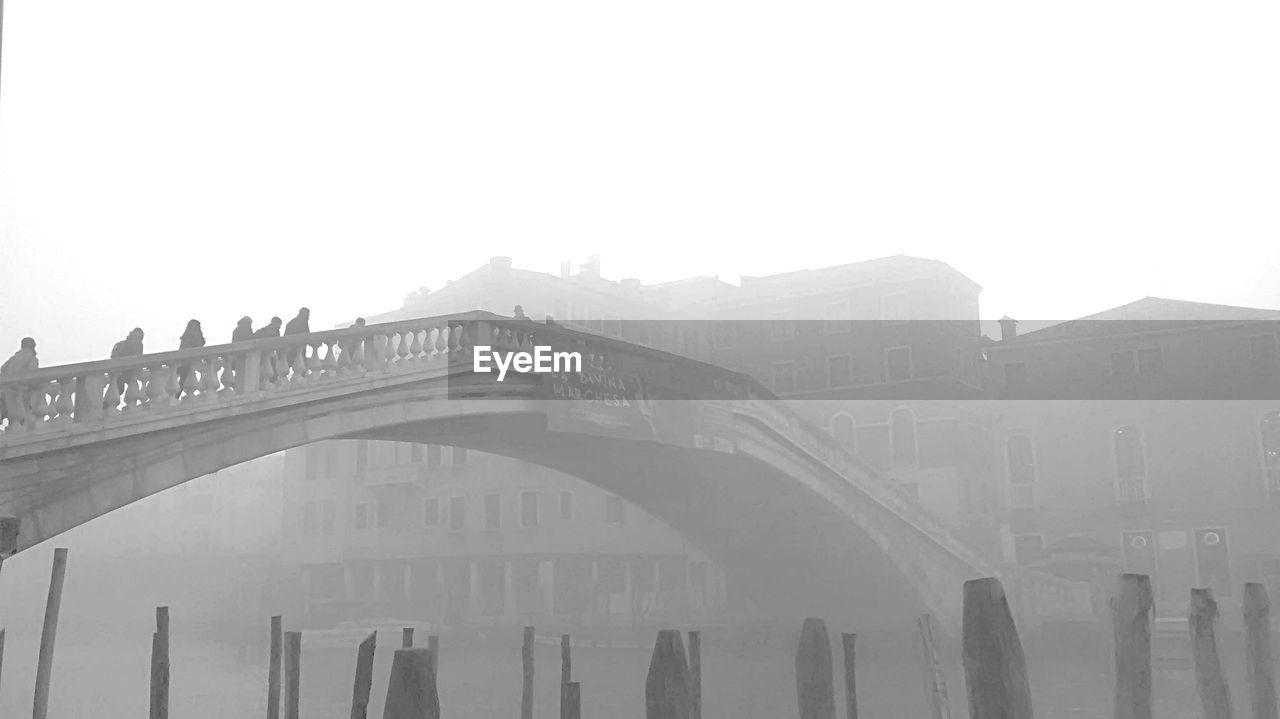 Ponte degli scalzi over canal against buildings during foggy weather
