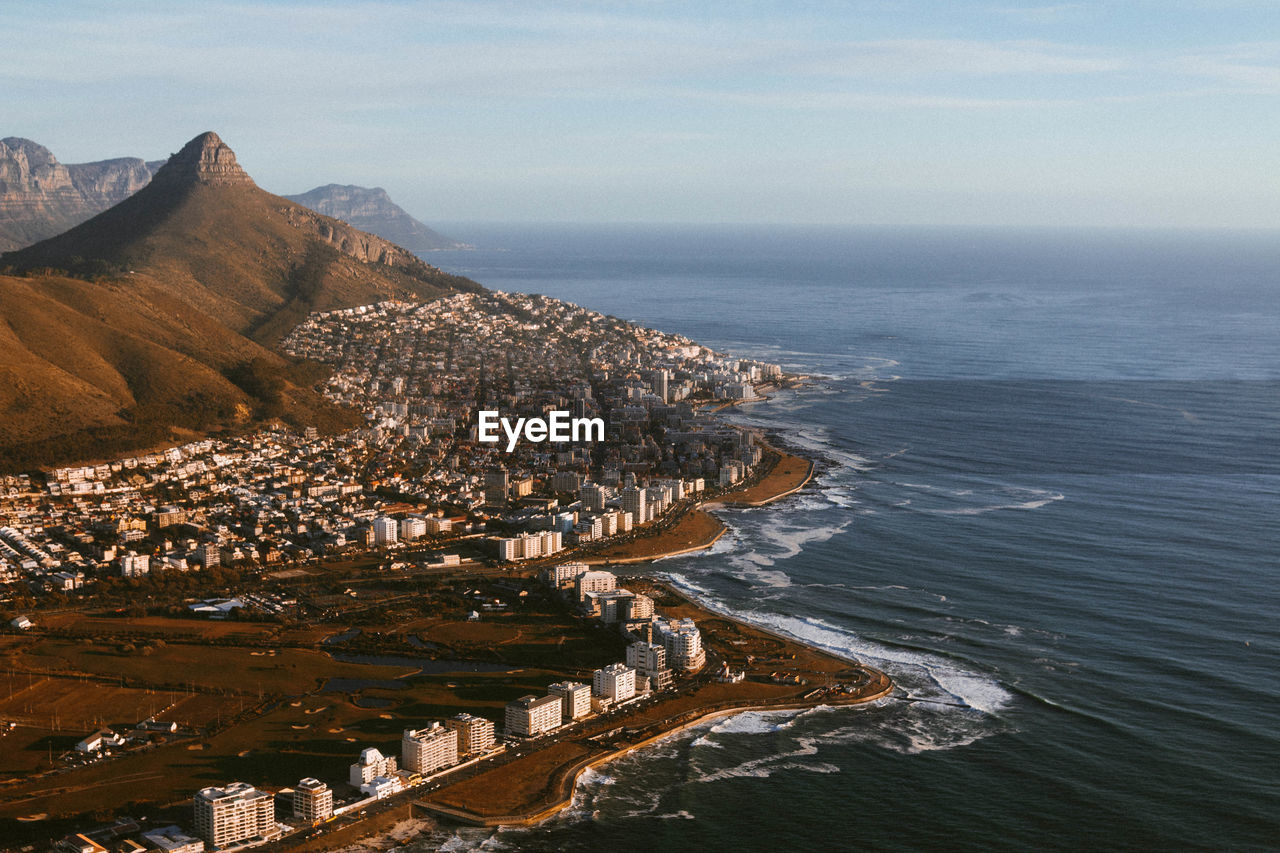 Scenic view of sea by mountains against sky