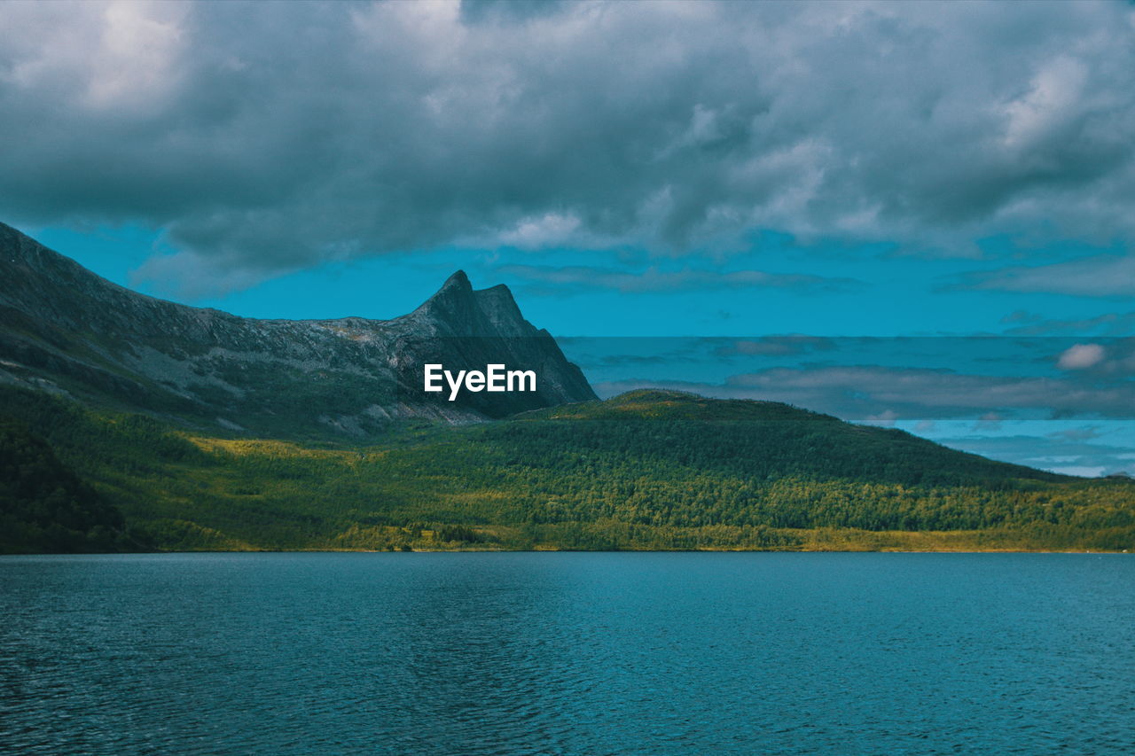 Scenic view of lake by mountains against sky