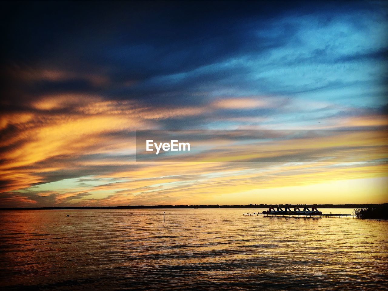 SILHOUETTE BOATS IN SEA AGAINST DRAMATIC SKY