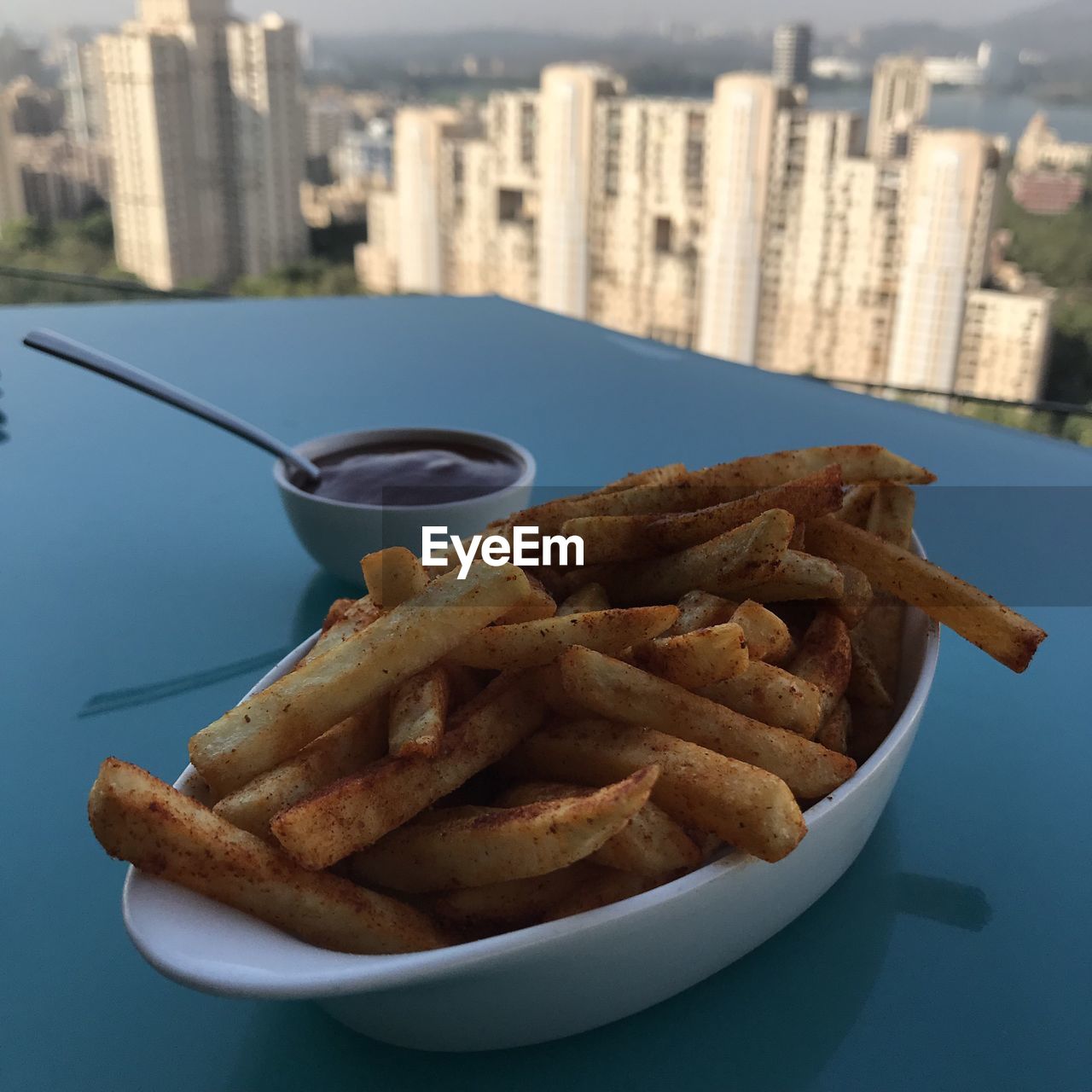CLOSE-UP OF FRIES WITH MEAT ON TABLE IN CITY
