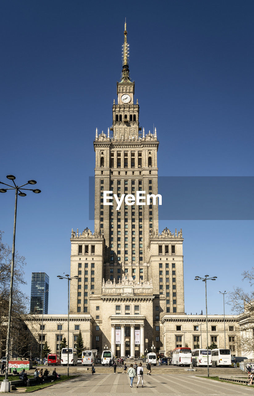 architecture, built structure, building exterior, city, landmark, building, travel destinations, tower, sky, cityscape, street, travel, nature, skyscraper, downtown, transportation, clear sky, plaza, car, blue, road, metropolis, town square, tourism, sunny, mode of transportation, motor vehicle, day, outdoors, tower block, history, urban area, city life, the past, office building exterior, city street