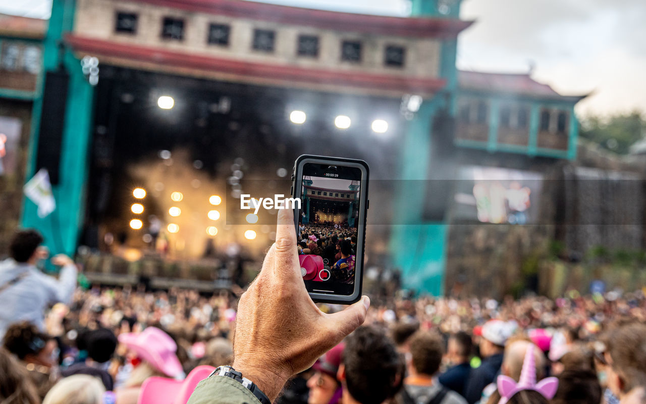 GROUP OF PEOPLE PHOTOGRAPHING AT MUSIC FESTIVAL