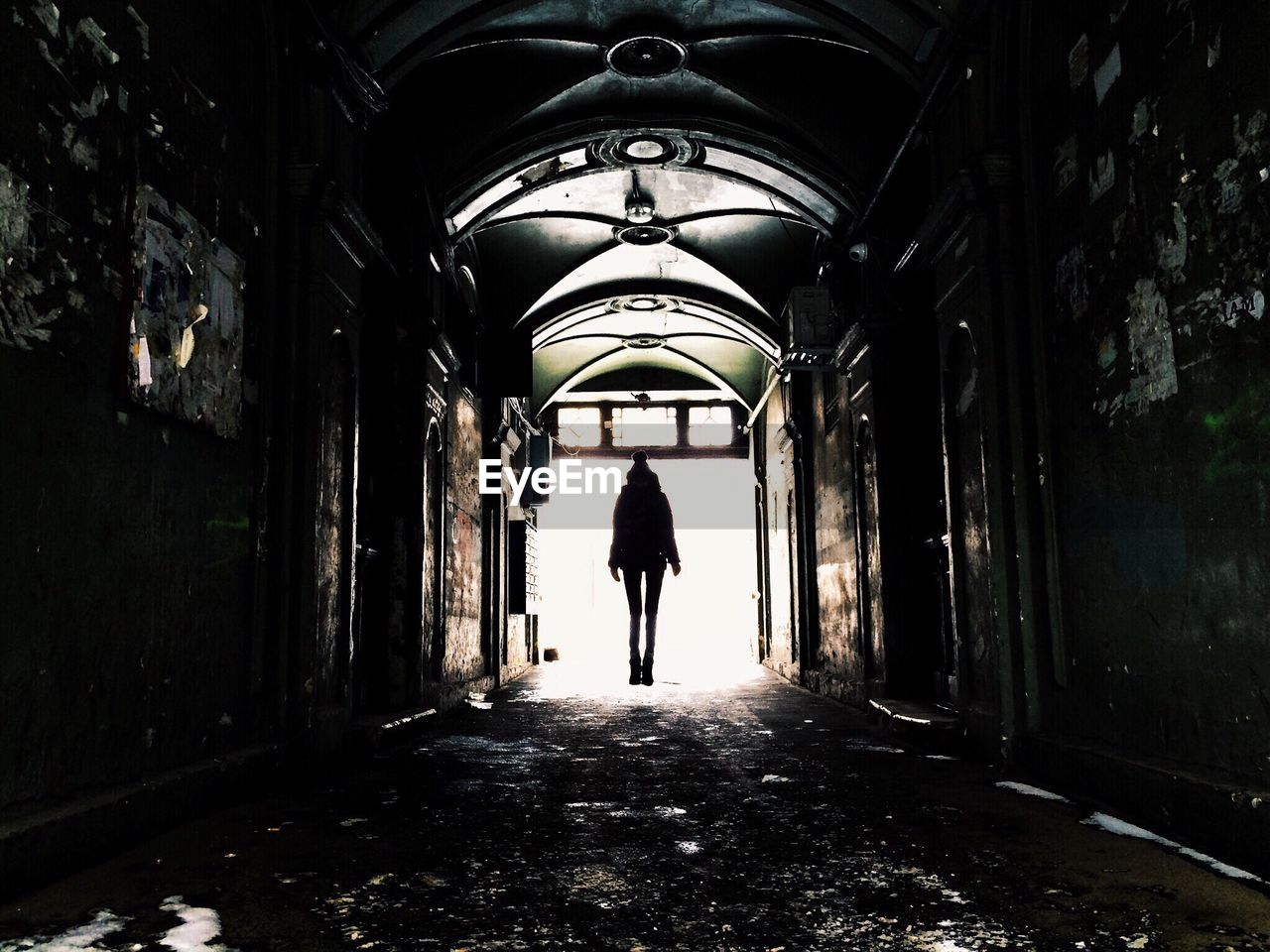 Silhouette woman levitating at corridor of abandoned building