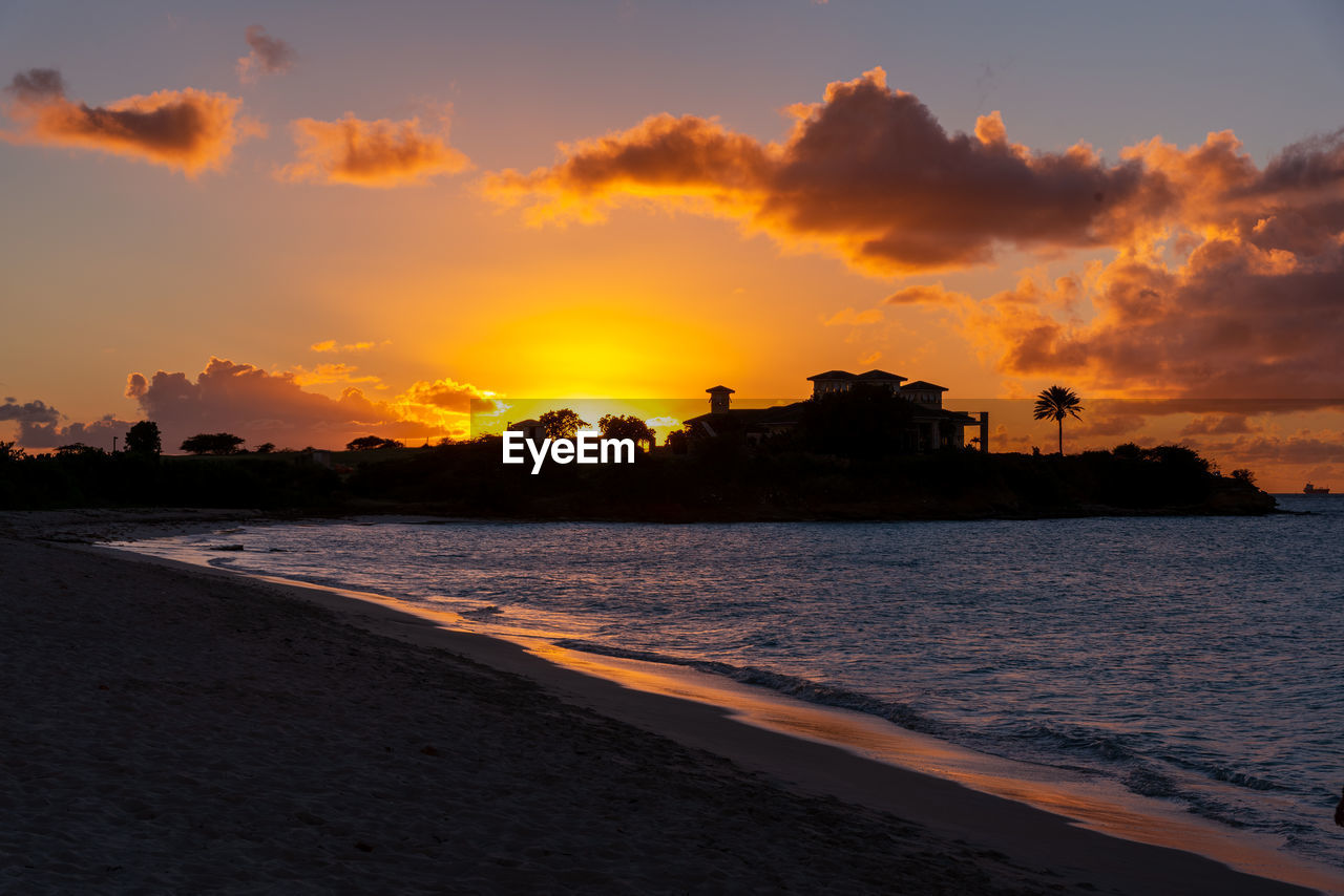 sky, water, sunset, sea, land, beach, cloud, horizon, nature, coast, ocean, dawn, beauty in nature, architecture, scenics - nature, shore, afterglow, travel destinations, evening, environment, landscape, wave, tranquility, travel, sun, orange color, built structure, building exterior, sand, no people, outdoors, city, coastline, seascape, building, holiday, body of water, sunlight, dramatic sky, vacation, bay, tranquil scene, tourism, trip, idyllic, silhouette, motion