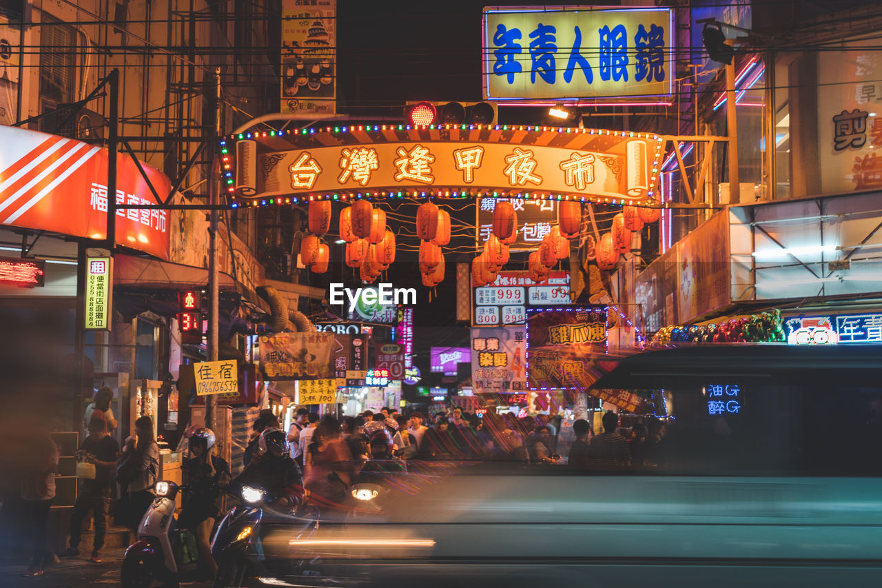 Crowd in illuminated city at night